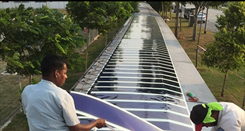 Two employees installing the first phase of HeliaFilm® on aluminum in Singapore