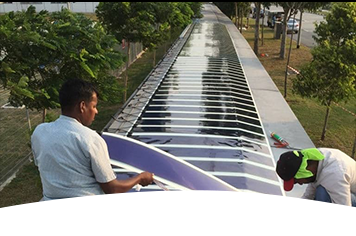 Two employees installing the first phase of HeliaFilm® on aluminum in Singapore
